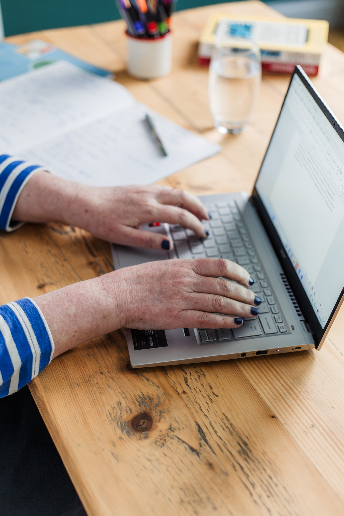 hands on a laptop on wooden desk